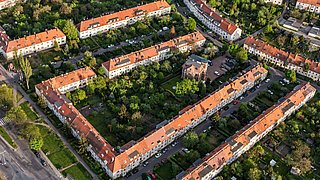 Foto, Luftbild einer städtischen Siedlung bestehend aus Mehrfamilienwohnhaus-Blöcken, einzeln stehende Mehrfamilienwohnhäusern sowie einigen Einfamilienwohnhäusern.